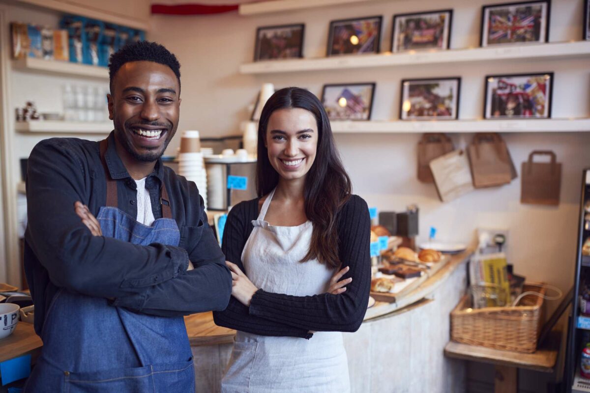 Smiling small business owners running coffee shop with crowdfunding support